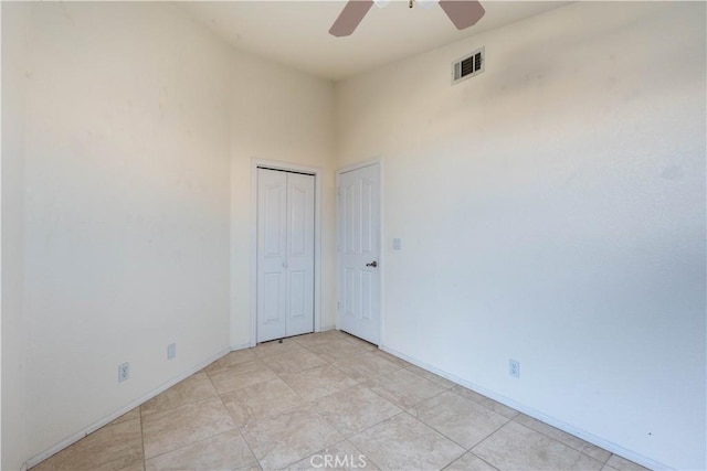 spare room with a ceiling fan, visible vents, and baseboards