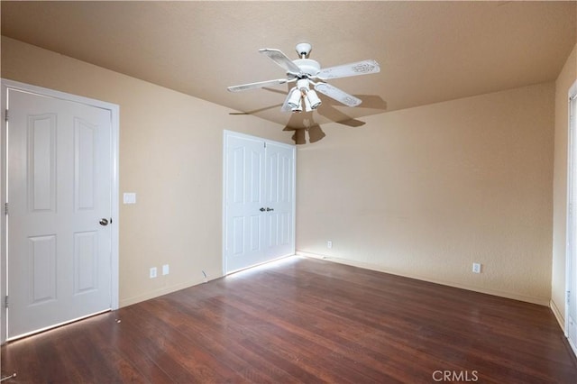 unfurnished bedroom with ceiling fan, a closet, baseboards, and wood finished floors