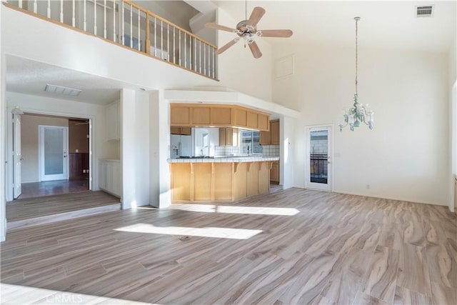 kitchen with visible vents, a kitchen breakfast bar, light wood-style floors, and open floor plan