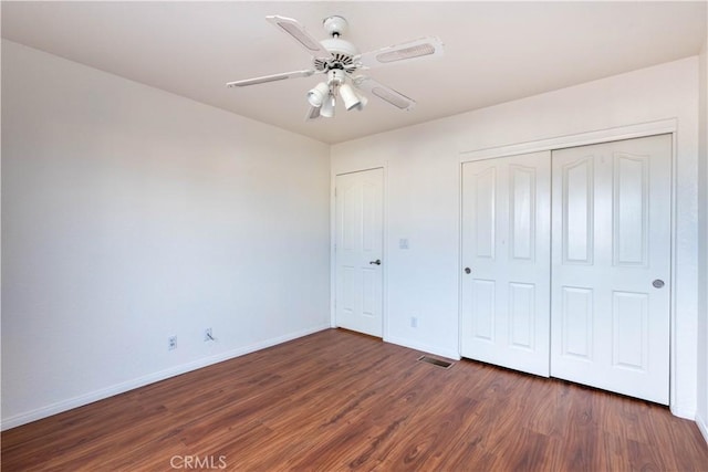 unfurnished bedroom featuring visible vents, a ceiling fan, wood finished floors, a closet, and baseboards