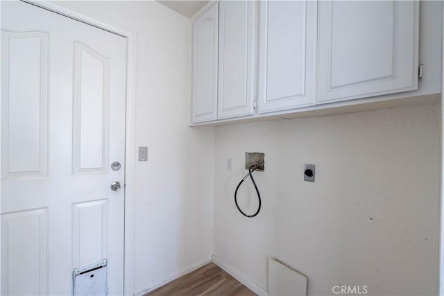 laundry area with hookup for a washing machine, baseboards, hookup for an electric dryer, light wood-style flooring, and cabinet space