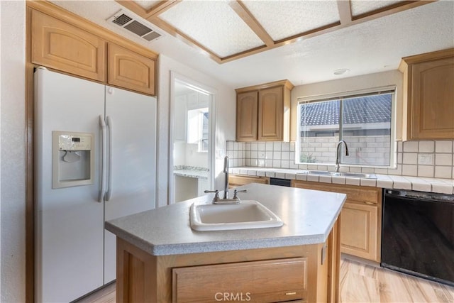 kitchen featuring a sink, visible vents, white fridge with ice dispenser, and black dishwasher