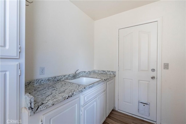 laundry room featuring a sink, light wood-style flooring, and laundry area