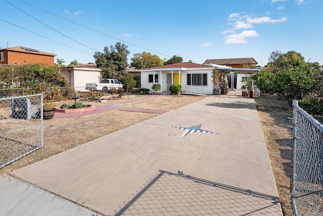 ranch-style house featuring concrete driveway, fence, and stucco siding