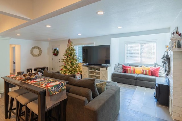 living room with a brick fireplace and light hardwood / wood-style flooring