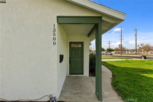 entrance to property featuring a yard