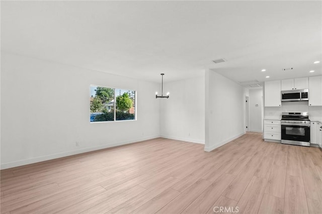 unfurnished living room featuring light hardwood / wood-style flooring and a notable chandelier