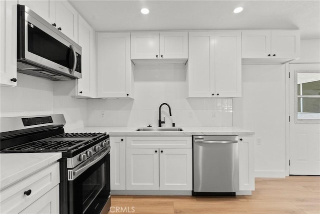 kitchen with white cabinets, sink, and appliances with stainless steel finishes