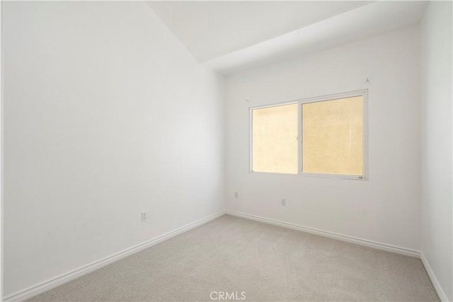 unfurnished room featuring light carpet and lofted ceiling