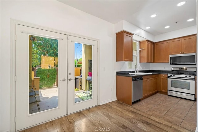 kitchen featuring light wood-type flooring, stainless steel appliances, a wealth of natural light, and french doors