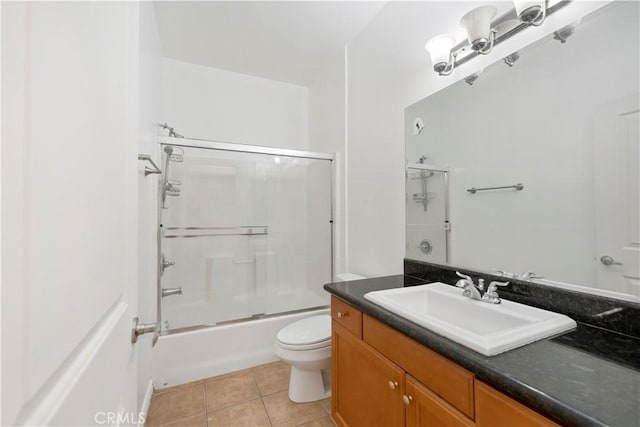 full bathroom with shower / bath combination with glass door, vanity, tile patterned floors, and toilet