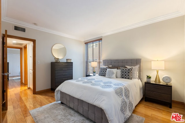 bedroom featuring crown molding and light hardwood / wood-style flooring