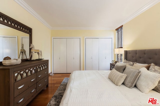 bedroom featuring crown molding, multiple closets, and hardwood / wood-style flooring