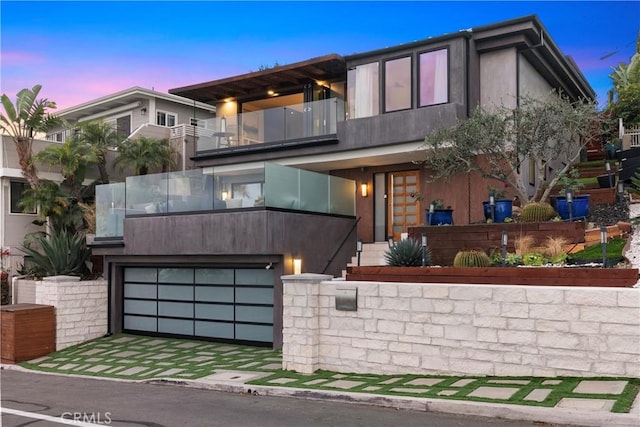 contemporary house with a garage and a balcony