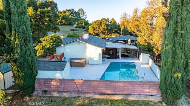 back of house with a fenced in pool and a patio