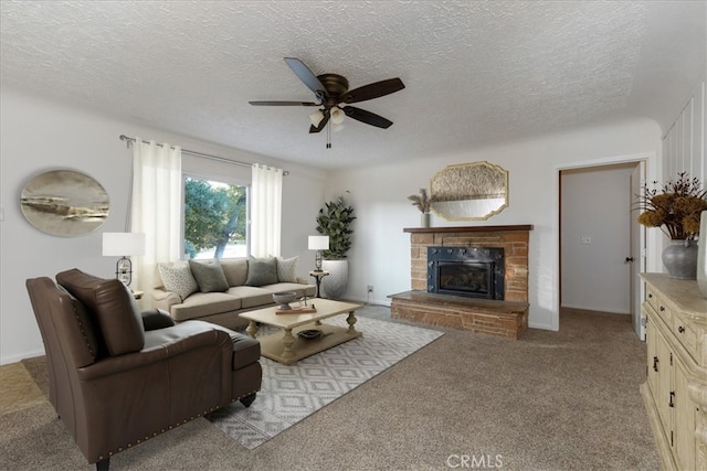 carpeted living room with ceiling fan, a fireplace, and a textured ceiling