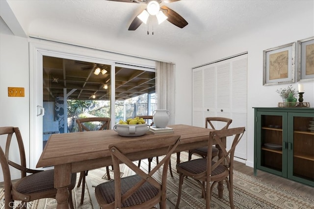 dining area with a textured ceiling, hardwood / wood-style flooring, and ceiling fan