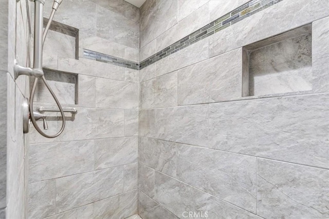 interior details with a tile shower