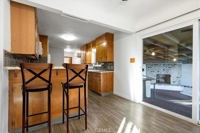 kitchen with tasteful backsplash, a breakfast bar, and dark wood-type flooring