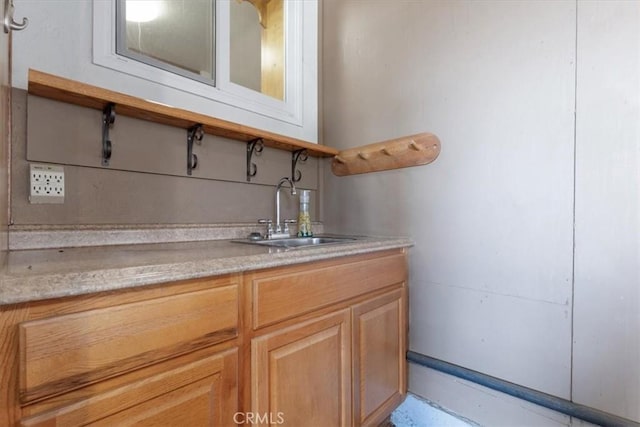 bar with light brown cabinets and sink