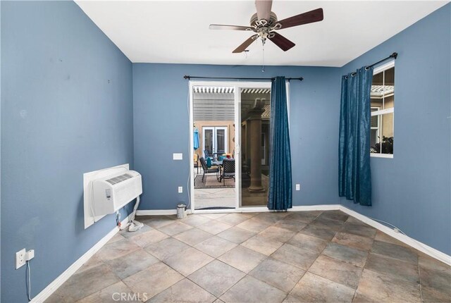 unfurnished room featuring an AC wall unit, ceiling fan, and a healthy amount of sunlight