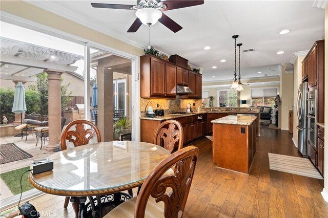 dining room featuring hardwood / wood-style floors, ceiling fan, and crown molding