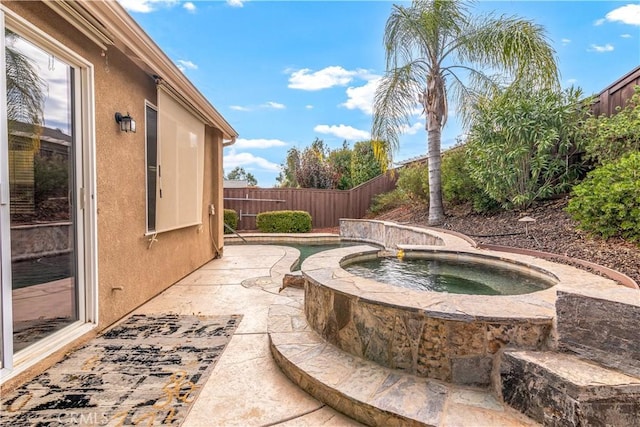 view of patio / terrace with a fenced backyard and an in ground hot tub