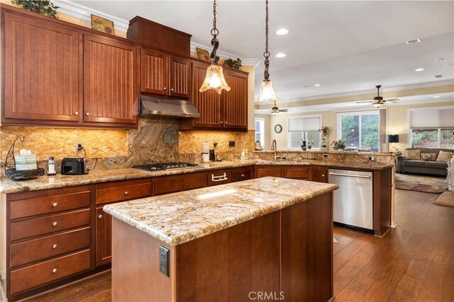 kitchen featuring pendant lighting, crown molding, a kitchen island, dark hardwood / wood-style flooring, and stainless steel appliances