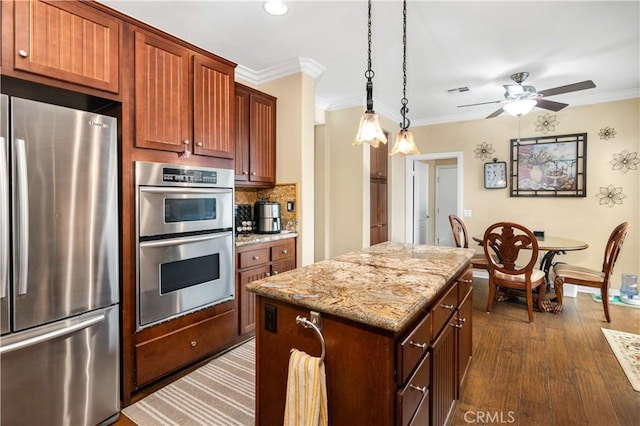 kitchen with a kitchen island, appliances with stainless steel finishes, decorative backsplash, and ornamental molding