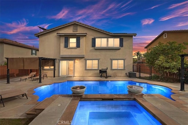 pool at dusk featuring an in ground hot tub, a patio, and cooling unit