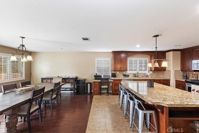 kitchen featuring a center island, decorative light fixtures, dark wood-type flooring, and a notable chandelier