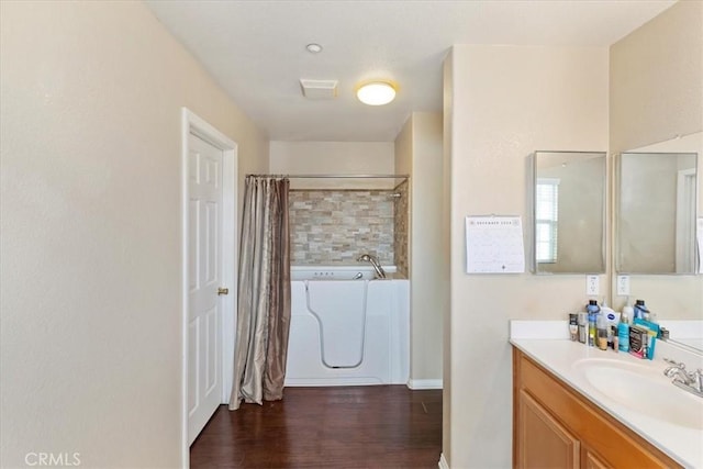 bathroom featuring hardwood / wood-style floors, vanity, and shower / bath combo