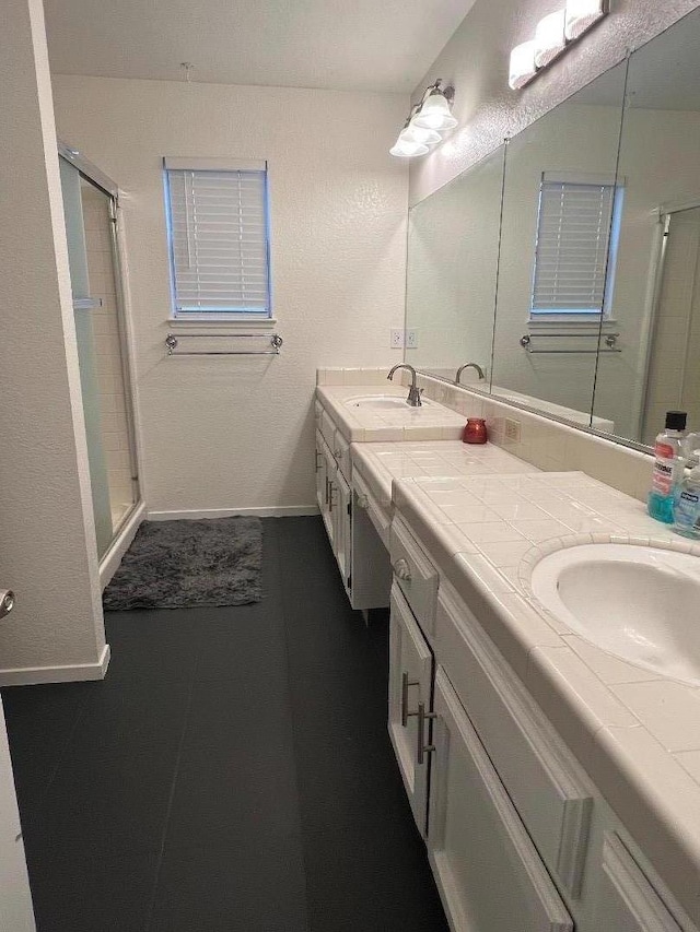 bathroom with tile patterned flooring, vanity, and a shower with door