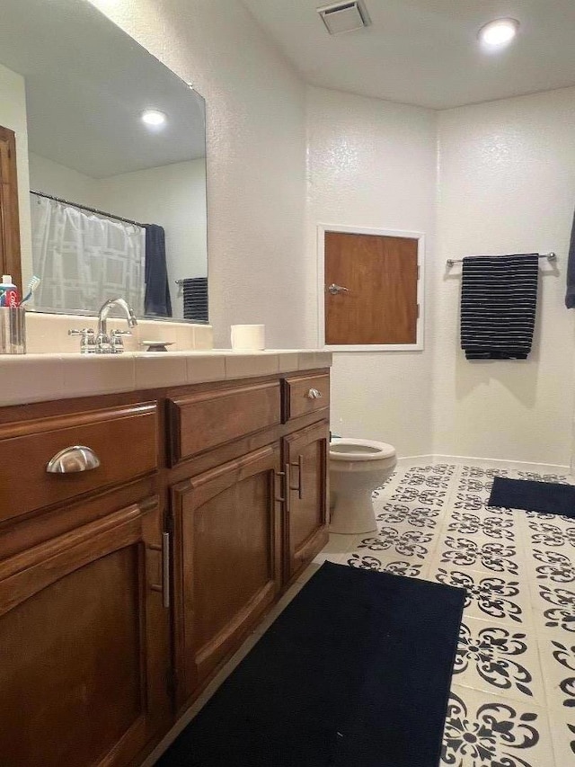 bathroom featuring tile patterned flooring, vanity, and toilet