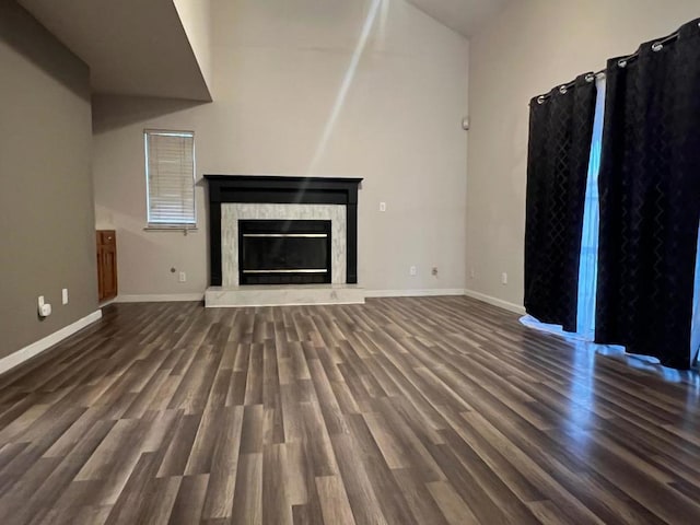 unfurnished living room featuring dark hardwood / wood-style floors and lofted ceiling