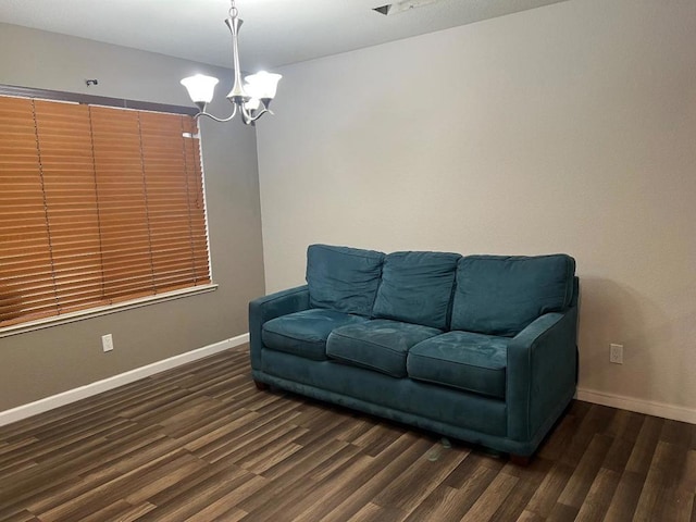 living area with dark wood-type flooring and a chandelier