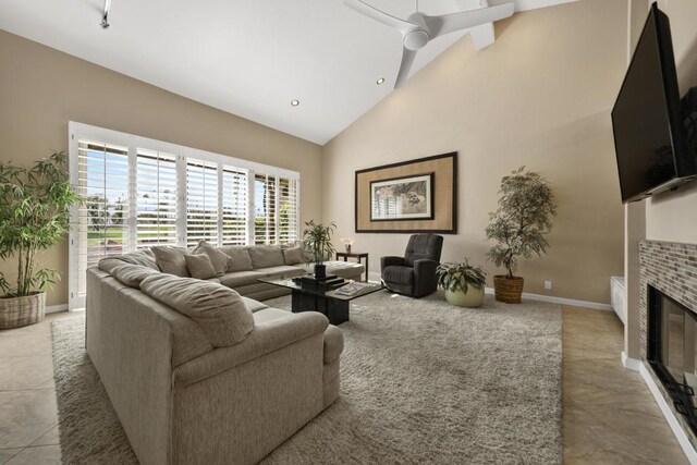 tiled living room with ceiling fan and high vaulted ceiling