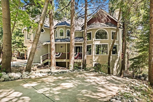 28670 Shenandoah Dr, Lake Arrowhead, CA 92352 - rear view of property featuring a chimney, a shingled roof, and a porch