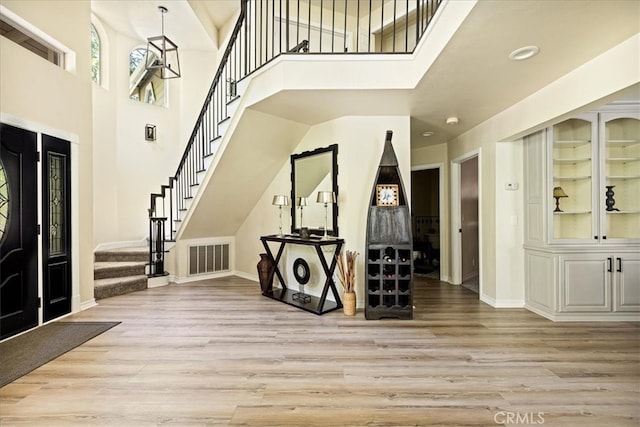 28670 Shenandoah Dr, Lake Arrowhead, CA 92352 - foyer entrance with light wood-style flooring, stairs, a high ceiling, and recessed lighting