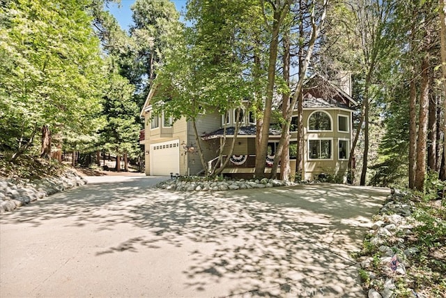 28670 Shenandoah Dr, Lake Arrowhead, CA 92352 - view of property hidden behind natural elements featuring concrete driveway and an attached garage