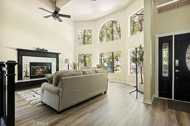 28670 Shenandoah Dr, Lake Arrowhead, CA 92352 - living room with a tiled fireplace, a high ceiling, ceiling fan, and wood finished floors