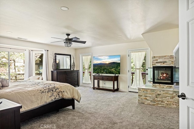 28670 Shenandoah Dr, Lake Arrowhead, CA 92352 - carpeted bedroom with access to exterior, multiple windows, a fireplace, and a ceiling fan