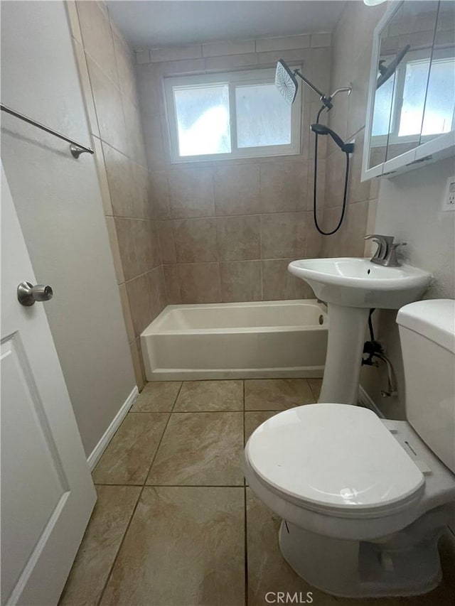 bathroom featuring tile patterned flooring, tiled shower / bath combo, and toilet