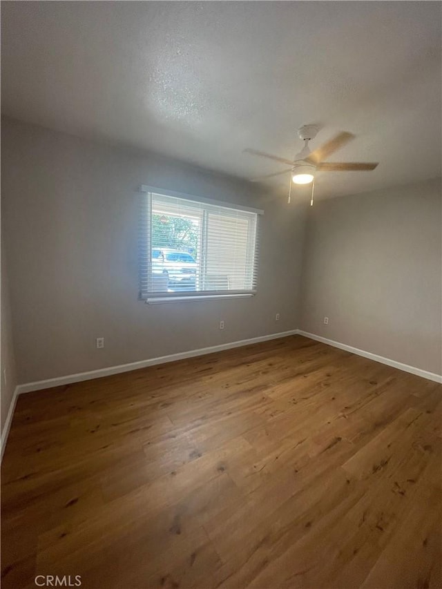 unfurnished room with ceiling fan and hardwood / wood-style flooring