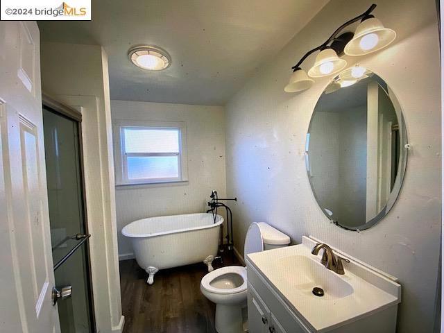 bathroom with hardwood / wood-style floors, a bathtub, toilet, and vanity