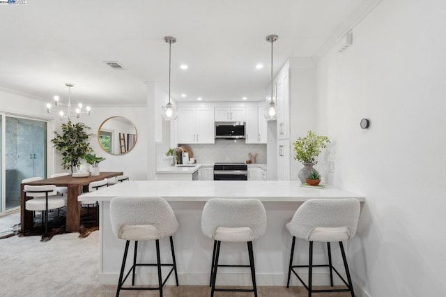 kitchen featuring white cabinets, sink, tasteful backsplash, kitchen peninsula, and stainless steel appliances