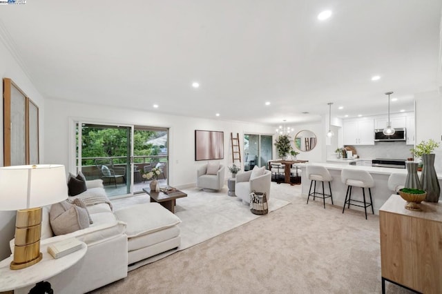 living room featuring ornamental molding, light colored carpet, and a chandelier