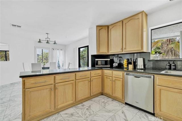 kitchen featuring sink, light brown cabinets, tasteful backsplash, kitchen peninsula, and appliances with stainless steel finishes