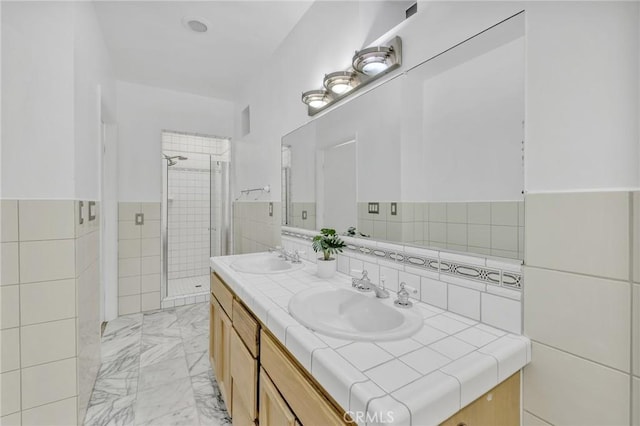 bathroom featuring vanity, a shower with shower door, and tile walls