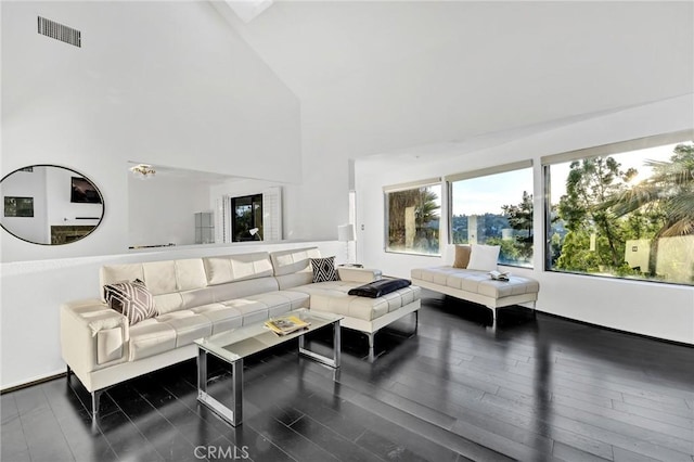 living room featuring dark hardwood / wood-style floors and high vaulted ceiling